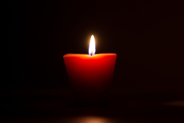 Closeup of burning candle isolated on black background.