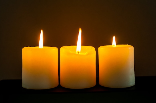 Closeup to burning candles in darkness