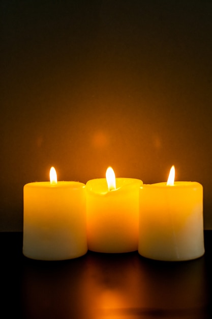 Closeup to burning candles in darkness