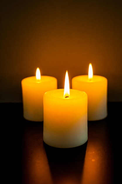 Closeup to burning candles in darkness