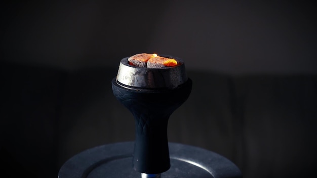 물담뱃대에 불타는 불씨의 클로즈업 물담배가 부풀어 오르면 붉은 석탄이 점화됩니다 물담배 컵에 타는 붉은 석탄 물담배를 준비하는 과정