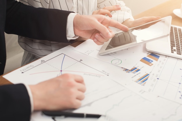 Closeup of business colleagues hands using tablet and working with documents. Financial background, count and pay an account, copy space