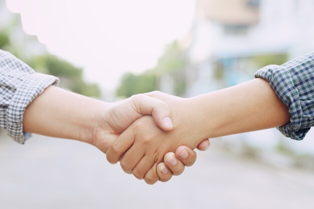 Photo closeup of a business hand shake between two colleagues plaid shirt