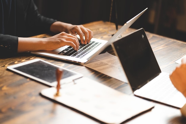 Closeup business hand working to typing computer laptop\
keyboard in modern office or home workplace desk table businessman\
using notebook for online technology communication job by using\
cyberspace