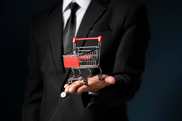 Closeup of business man hand holding trolley miniature