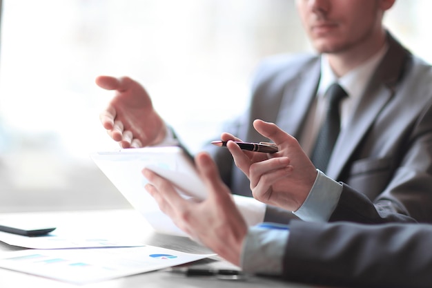 Closeup of business partners discussing document in touchpad