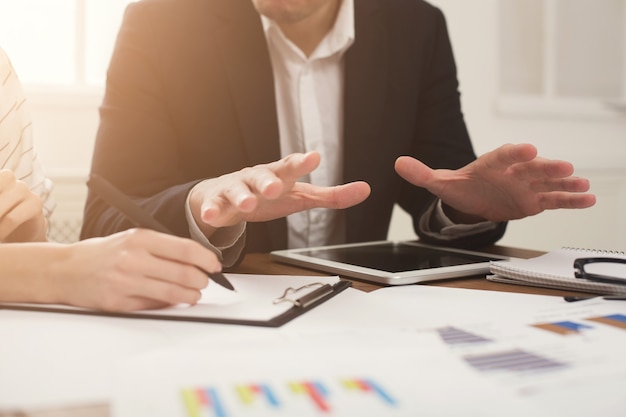 Closeup of business partners hands using tablet and working with documents. Financial background, count and pay an account, copy space