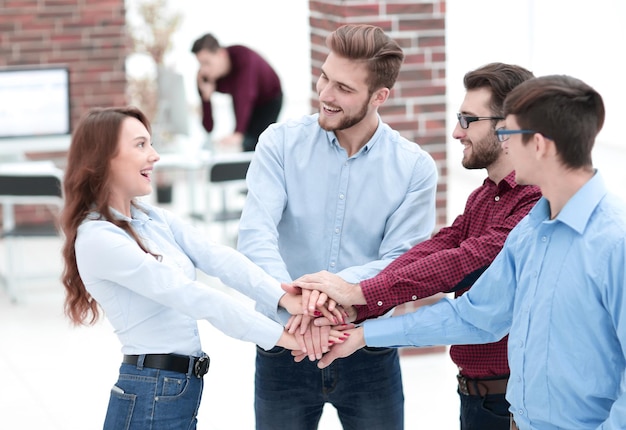 Foto primo piano dei partner commerciali che fanno il mucchio delle mani alla riunione