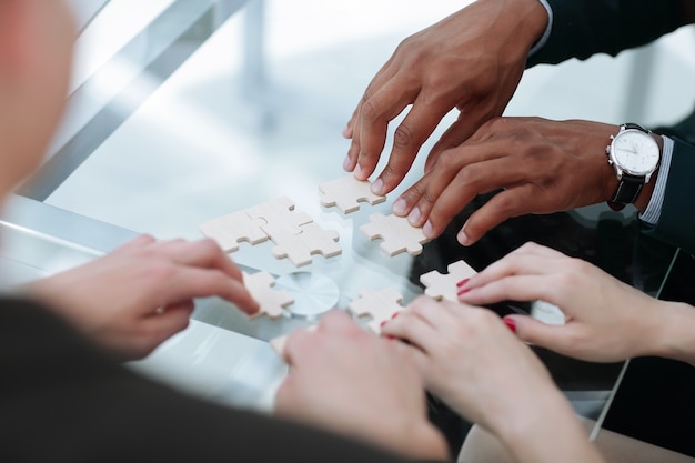 Avvicinamento. team aziendale che assembla i pezzi del puzzle.concetto soluzioni aziendali