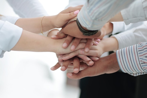 Closeup of business team putting their hands on top of each other