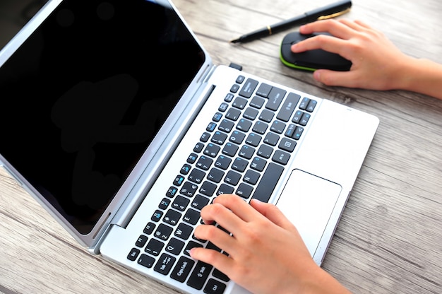 Closeup of business woman hand typing on laptop keyboard with mouse