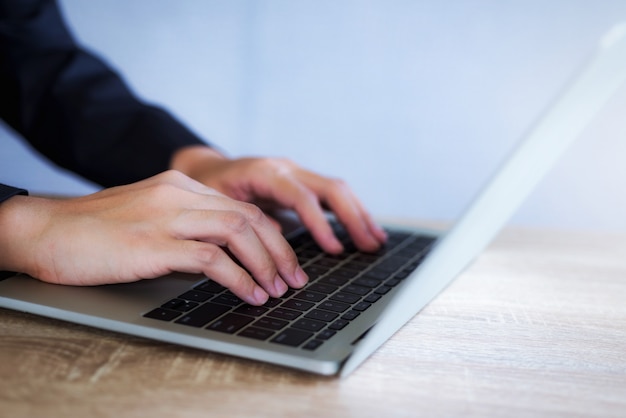 Primo piano della donna di affari che lavora per il nuovo progetto con il computer portatile all'ufficio soleggiato.