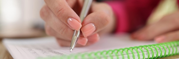 Closeup of business womans hand with pen writing note in notebook creativity new ideas and