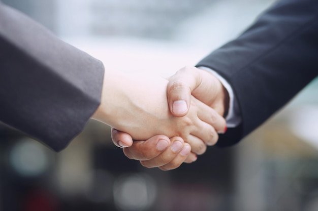 Closeup of a businessman hand shake businesswoman between two colleagues OK succeed in business Holding hands