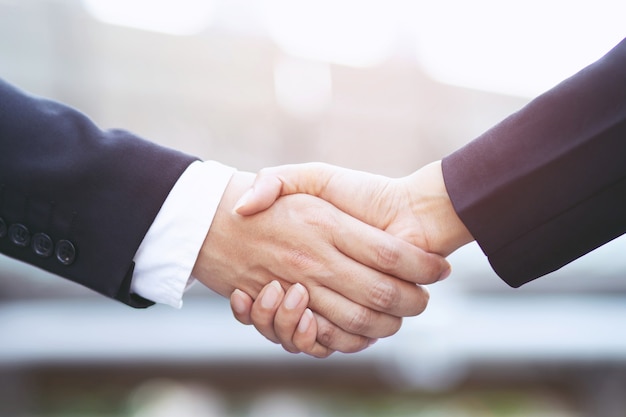 Closeup of a businessman hand shake businesswoman between two colleagues  OK, succeed in business Holding hands.