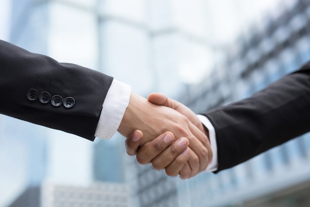 Closeup of a businessman hand shake investor between two colleagues