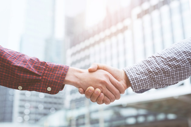 Closeup of a businessman handshake between two colleagues greet