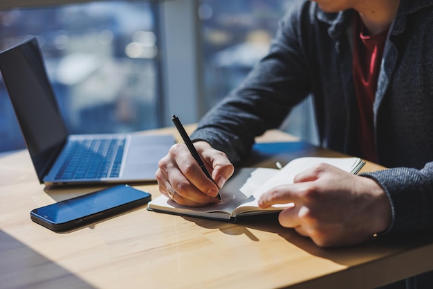 Closeup of a businessman's male hands with a notepad and a pen