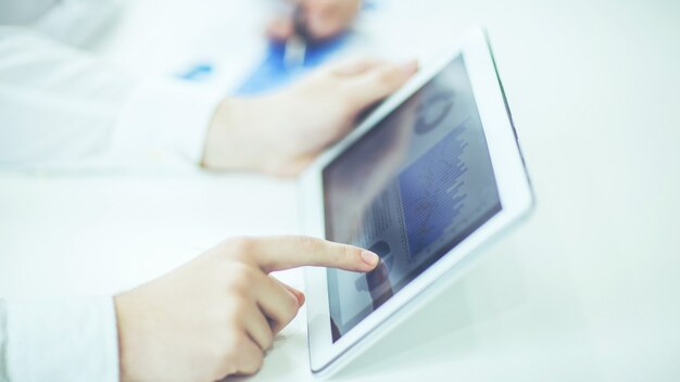 Closeup of businessman using digital tablet, working with the financial schedule at the Desk .the photo has a empty space for your text