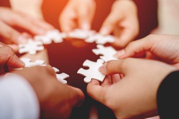 Closeup of businessman with puzzle pieces in office teamwork unity in teamwork The concept