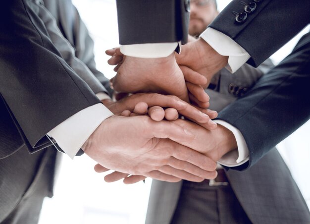 Closeup of businesspeople stacking hands in meeting