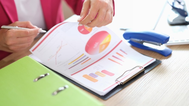 Closeup of businesswoman analysing financial and marketing documents in office statistics data