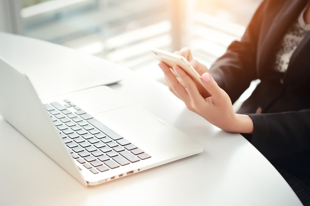 Closeup businesswoman hands using smart phone and touch screen 