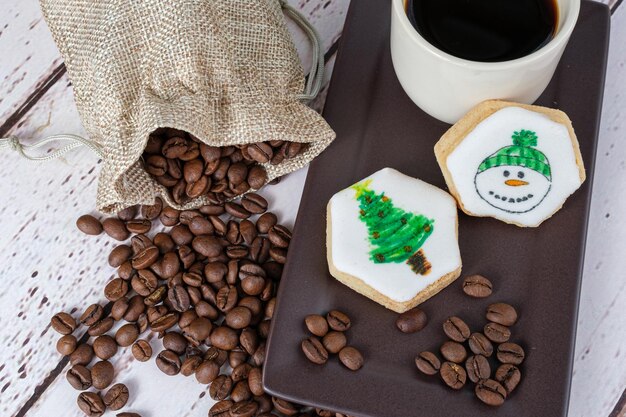 Closeup of buttery gout, with snowman sketch, next to coffee beans and cup (top view).