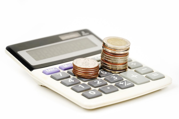 Closeup of calculator and coin isolated on white background