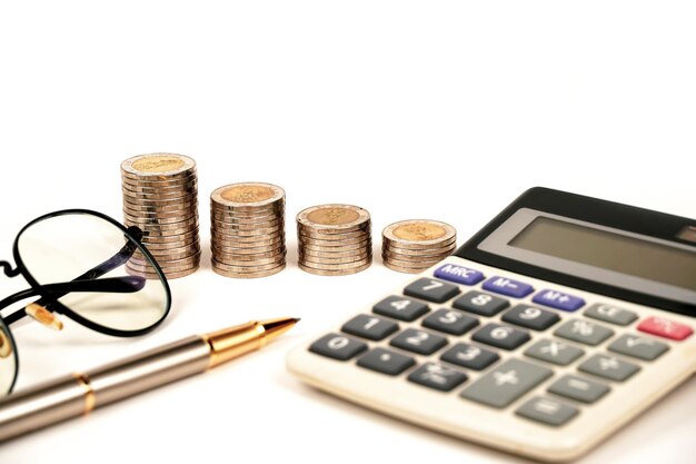 Closeup of calculator and coin with pen on business background