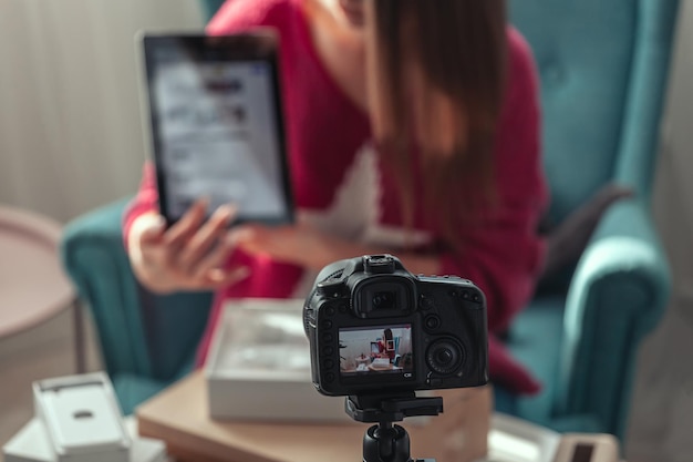 Photo closeup camera screen woman blogger makes video of unpacking gadgets at home