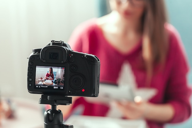 Foto lo schermo della fotocamera del primo piano, la donna blogger fa il video del disimballaggio