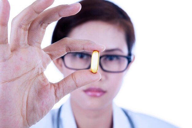 Photo closeup capsule hold by female doctor isolated