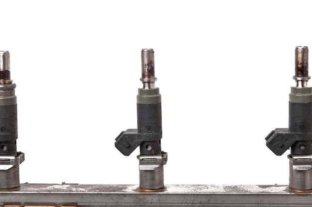 Photo closeup on a car fuel rail with injectors for supplying gasoline to eight cylinder engine on a white isolated background spare parts catalog