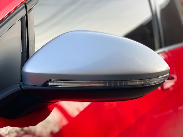 Closeup car mirror for viewing the blind spots of a red car car details