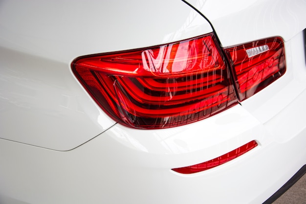 Closeup of car tail light on a white car.