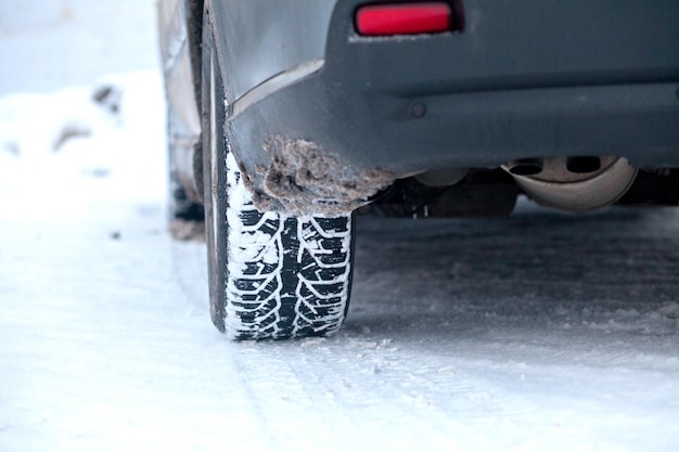 Closeup of car tires in winter on the road covered with snow