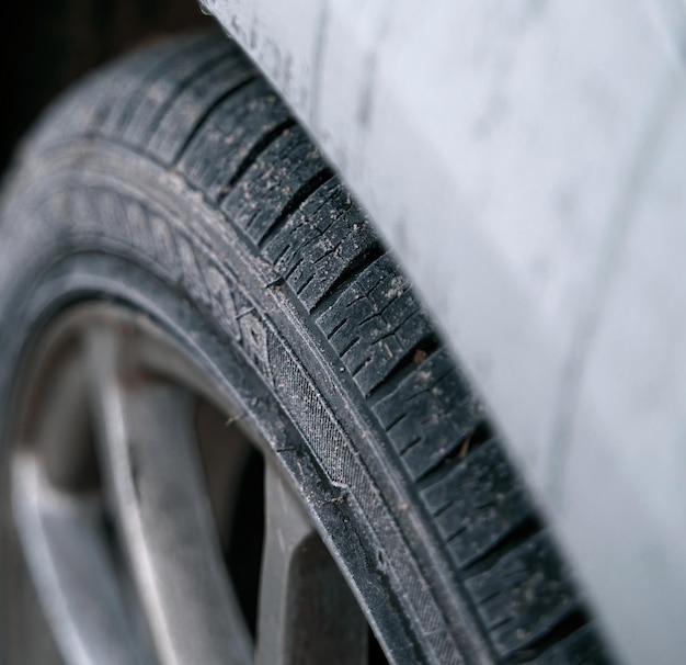 Closeup of car wheels rubber tires in winter snow Concept of transportation and safety during the winter season Selective focus