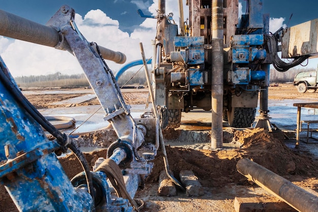 Closeup of a carbased drilling rig at a construction site\
drilling deep wells for mining working process of drilling a\
well
