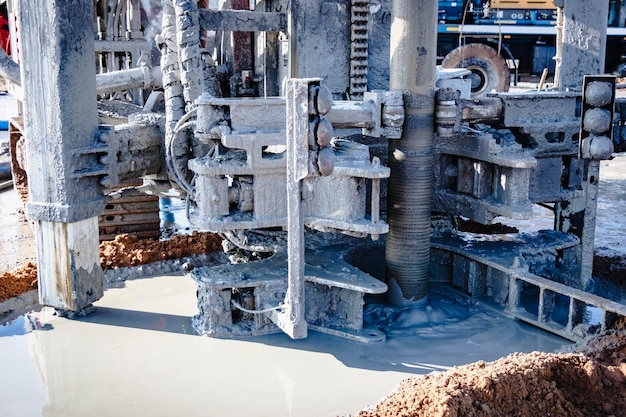 Closeup of a carbased drilling rig at a construction site\
drilling deep wells for mining working process of drilling a\
well