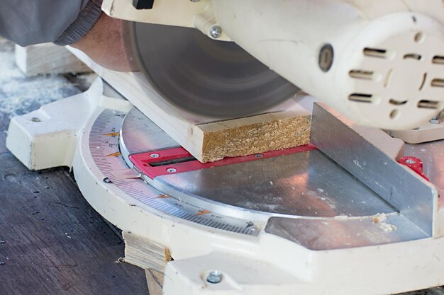 Closeup of carpenter cutting a wooden plank