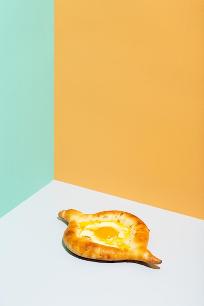 Closeup on caucasian flat bread adjarian khachapuri with egg on orange background high quality photo