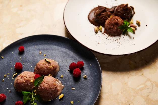 Closeup of ceramic plates with balls of raw vegan ice cream sorbet on a marble table background Food still life