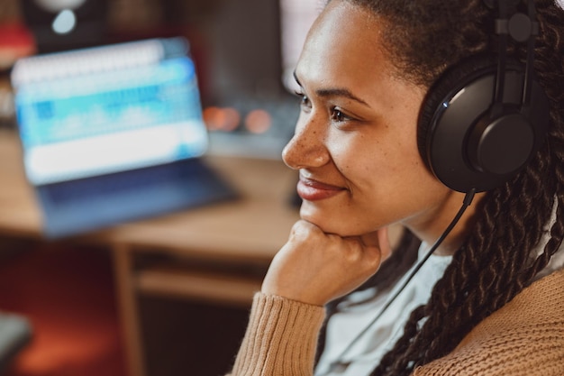 Closeup charmante Afrikaanse vrouw songwriter geluidstechnicus zanger met koptelefoon die aan muziek werkt