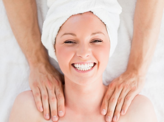 Closeup of a charming red-haired woman receiving a massage in a spa centre