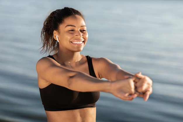 Closeup of cheerful african american woman stretching arms