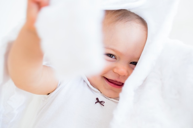 Макрофотография веселый милый ребенок под одеялом