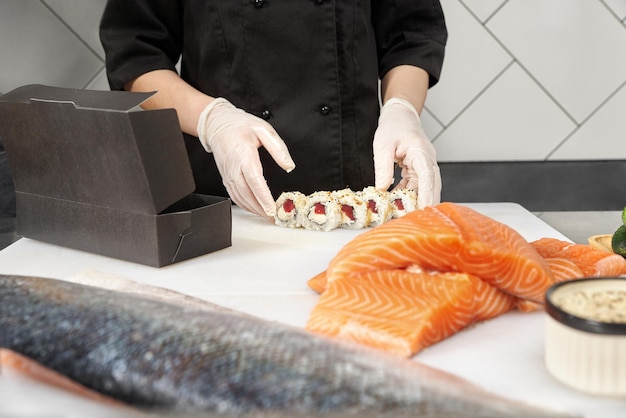 Closeup of chef hands preparing japanese food Japanese chef making sushi at restaurant chef making traditional japanese sushi on cuting board