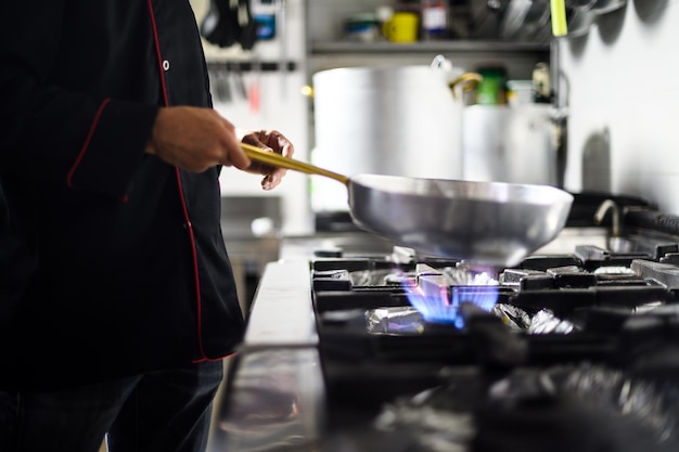 Photo closeup of a chef jumping verdures ina pan