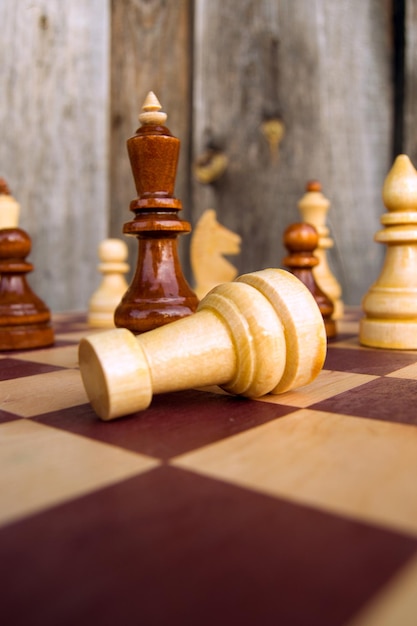 Closeup of chess pieces on a wooden background on a sunny day Concept board game and intellectual activity